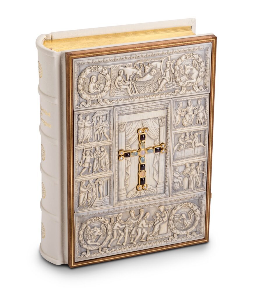 Bibel aufgestellt: Einband mit Elfenbein-Replikaten in edlem Holzrahmen. In der Mitte des Einbands sieht man ein echtvergoldetes Prachtkreuz mit Edelsteinen besetzt. Zwei echtvergoldete polierte Schließen runden das Meisterwerk ab.